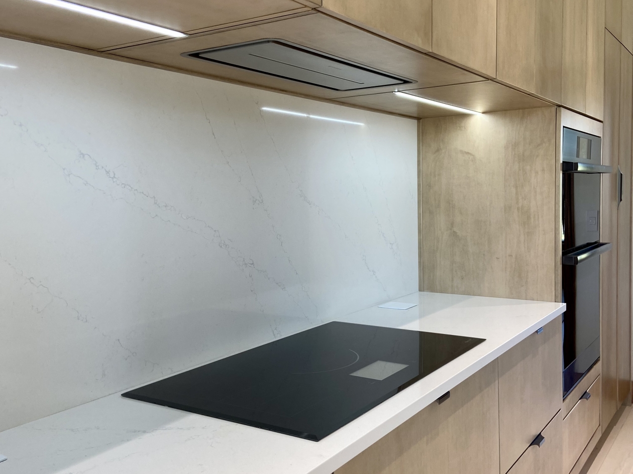 Mouse cabinetry, cooktop, doubl oven, Eurostyle cabinets, stained maple, custom undercabinet strip lighting, custom hood vent insert