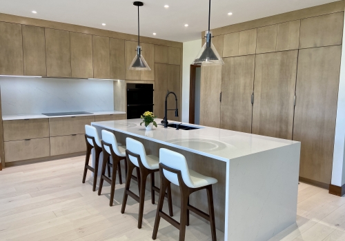 slide: Mouser cabinetry, Euro style cabinets, waterfall countertop, custom island, pendant lighting